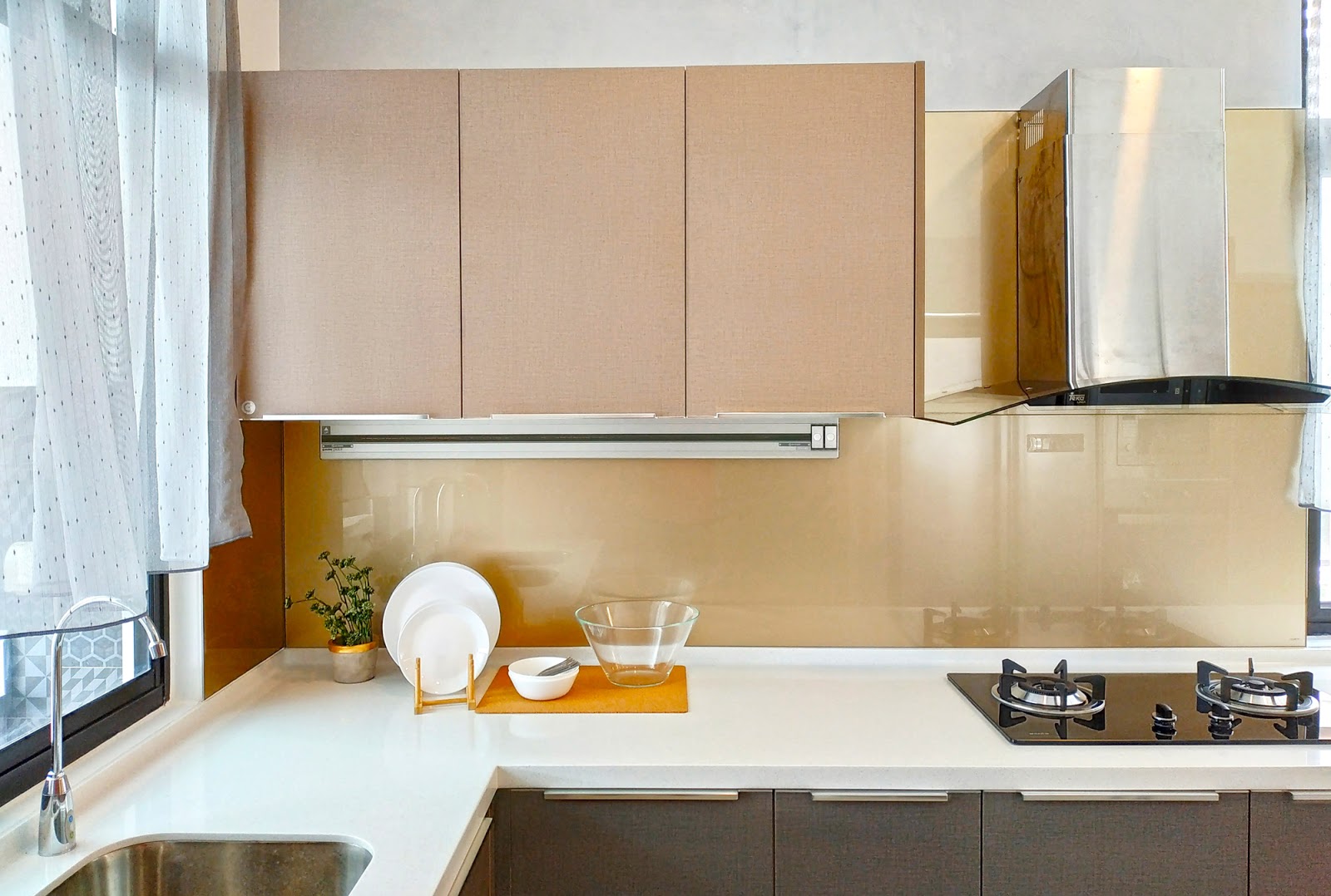 Kitchen area with built-in cabinets and a glossy backsplash.