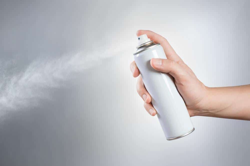 Spraying disinfectant aerosol spray into the air
