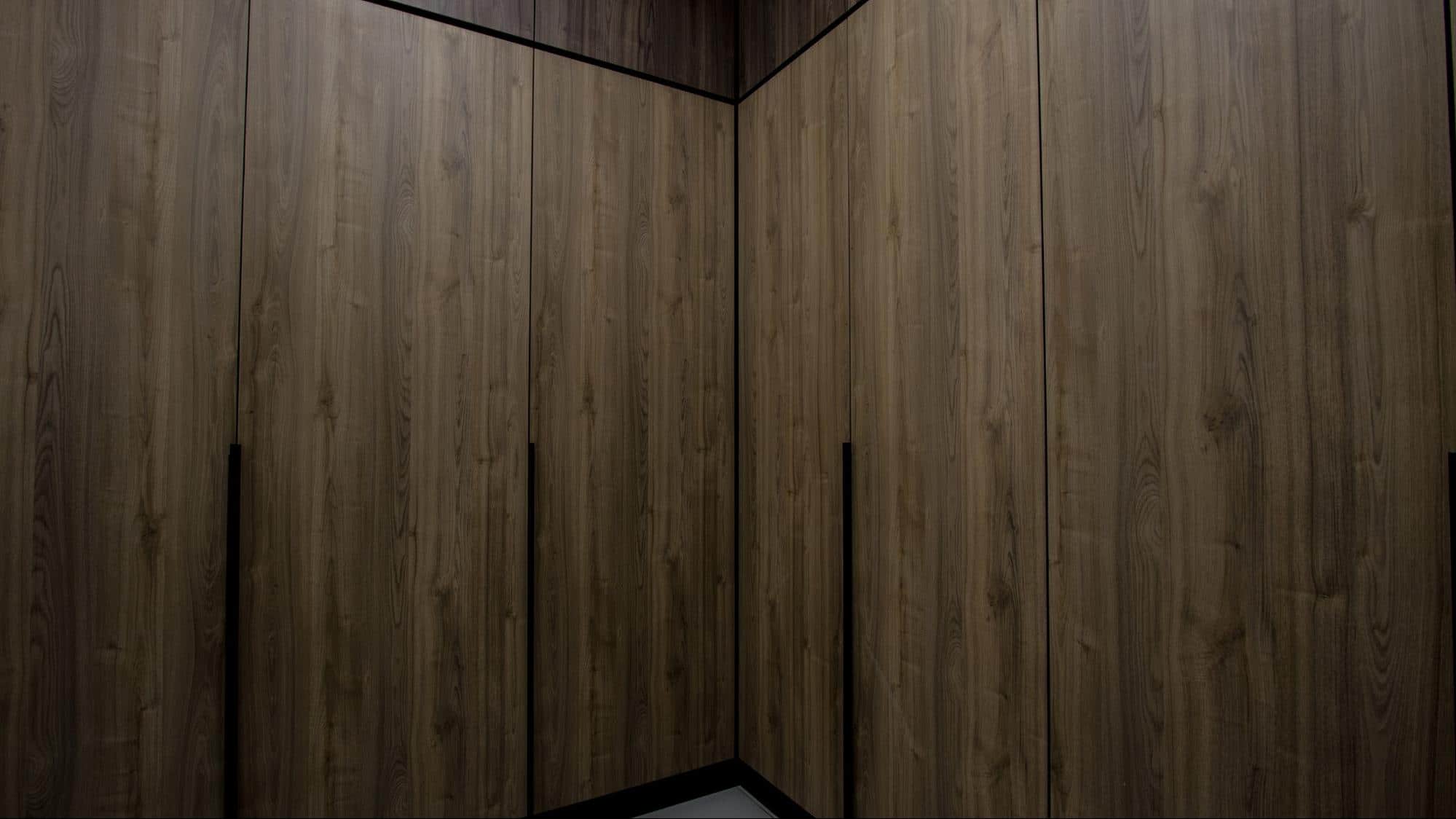 Walk-in wardrobe with brown built-in cabinetry