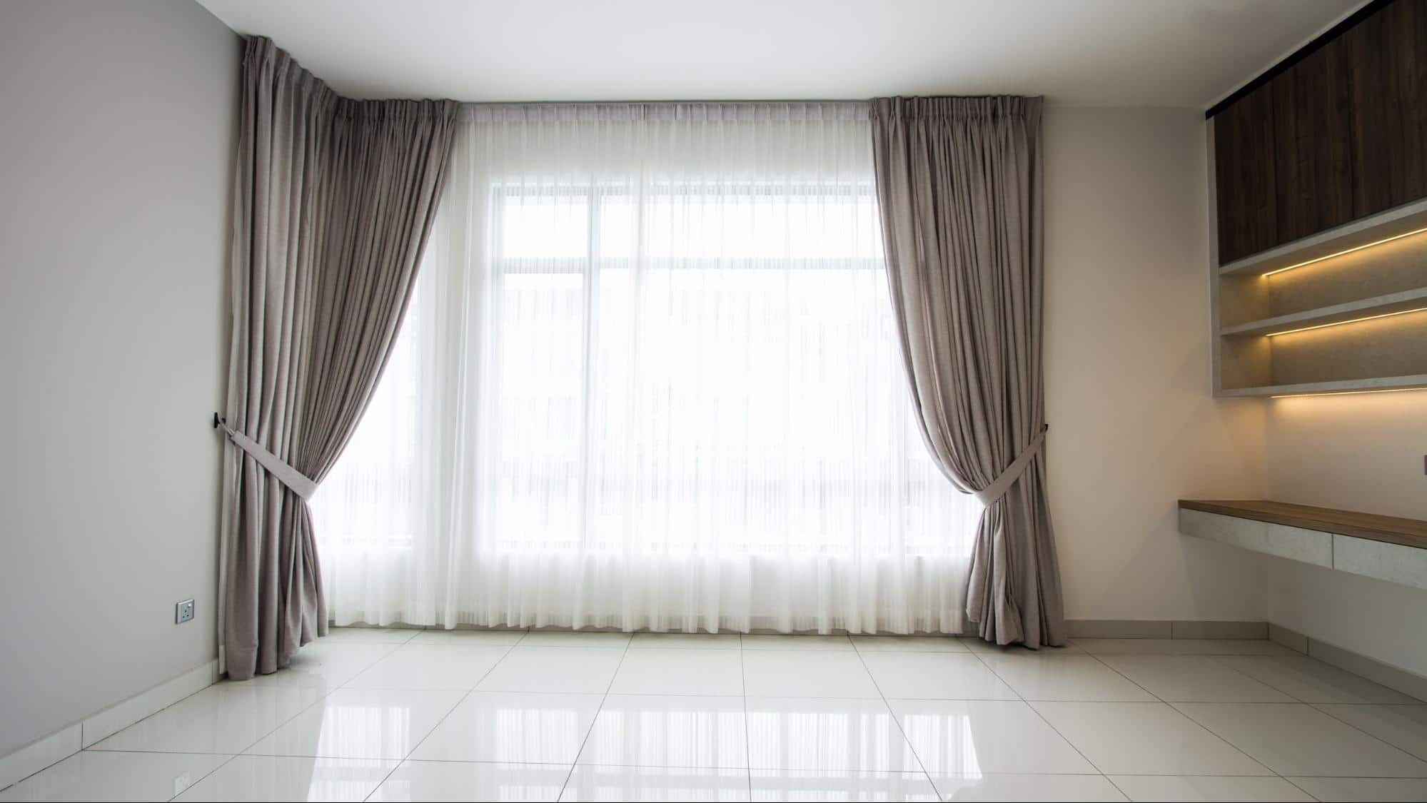 Floor length bedroom windows furnished with soft neutral tones
