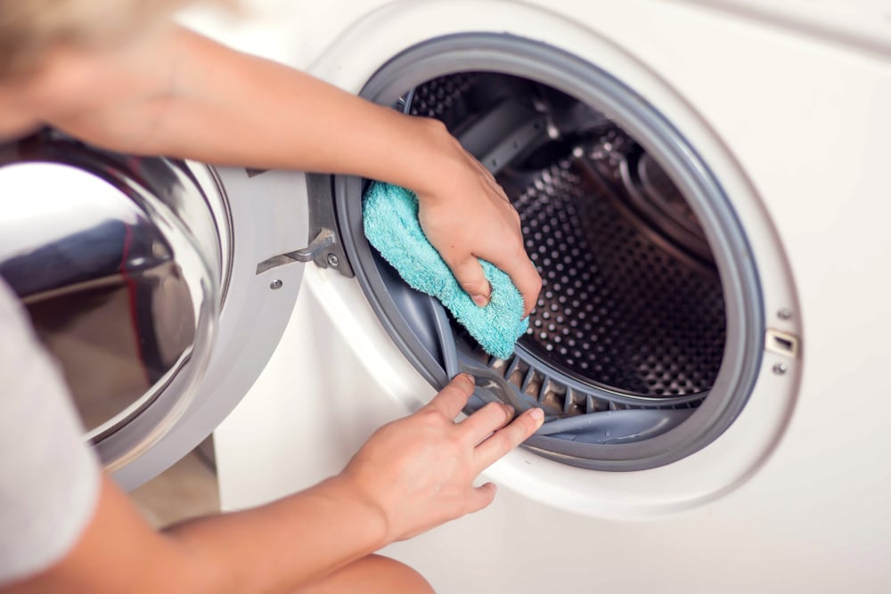 Wiping mildew and dirt off of a front-load washing machine rim 