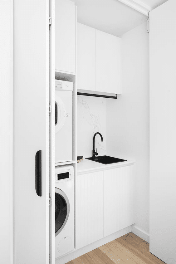 Hidden laundry area in ultra minimalist monochrome design 