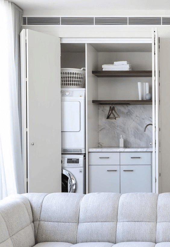All-white hidden laundry nook with bifold doors 
