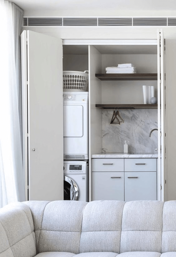 All-white hidden laundry nook with bifold doors