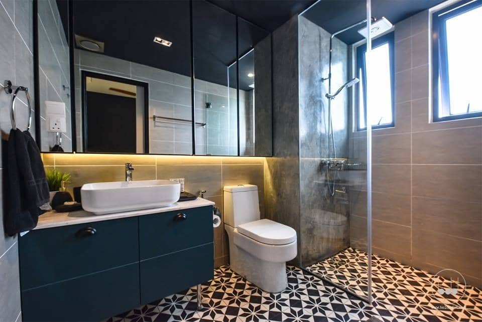 Above: Dark blue cabinets and rose-coloured wall tiles in the shower for this bathroom in Ascenda Residences, Setapak by Boldndot